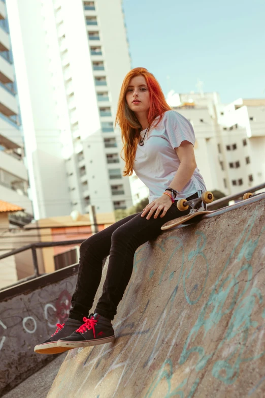 a woman sitting on a skateboard ramp with her legs stretched out