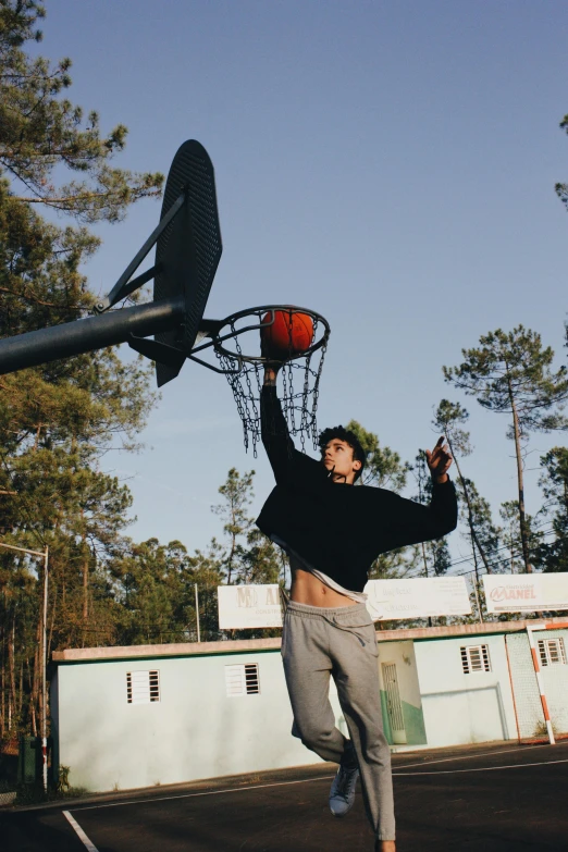 a man is about to dunk a basketball in the hoop