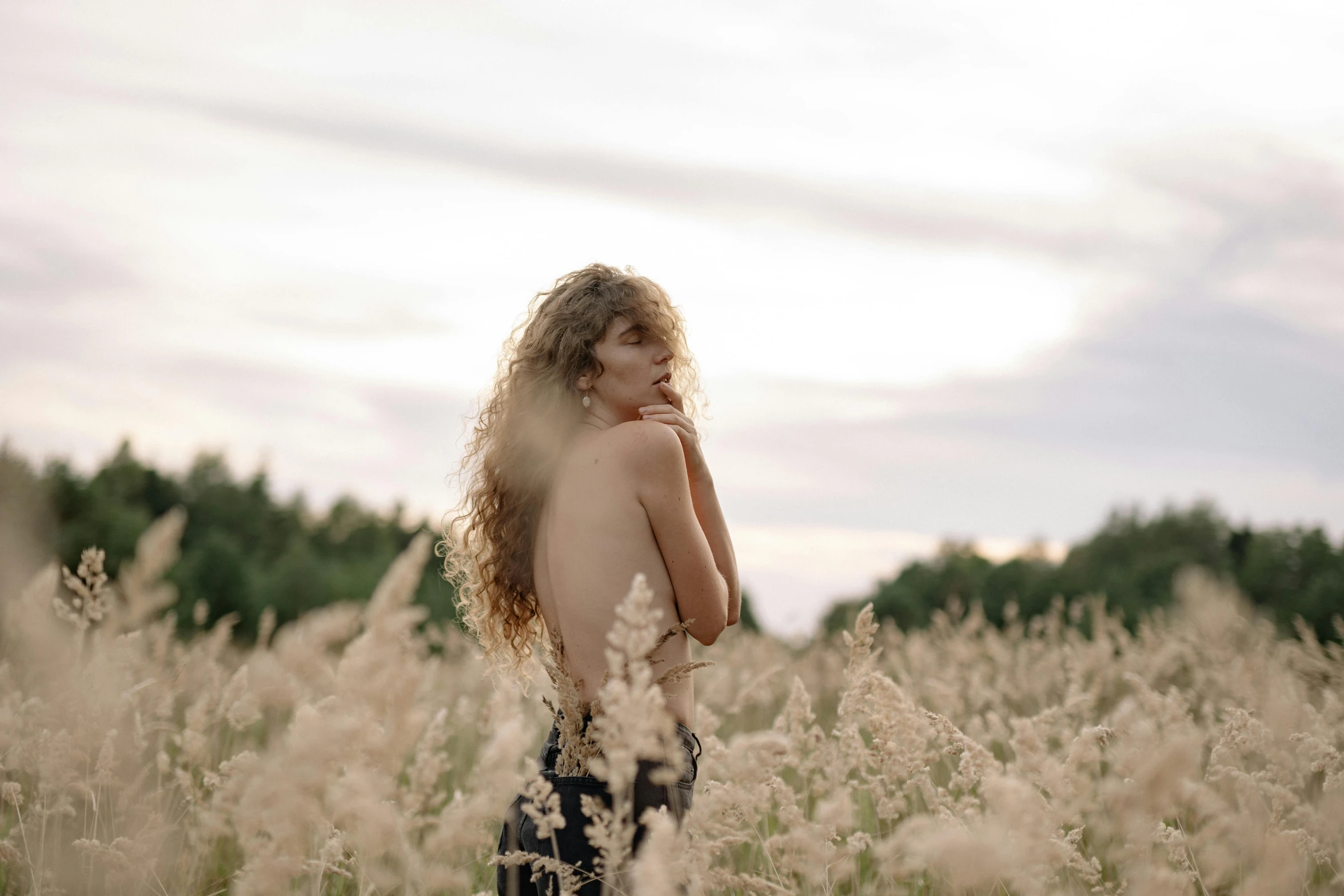  girl standing in tall grass staring ahead