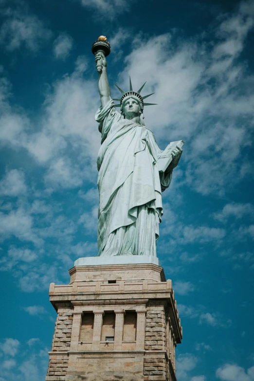 the statue of liberty looks very tall, holding two hands