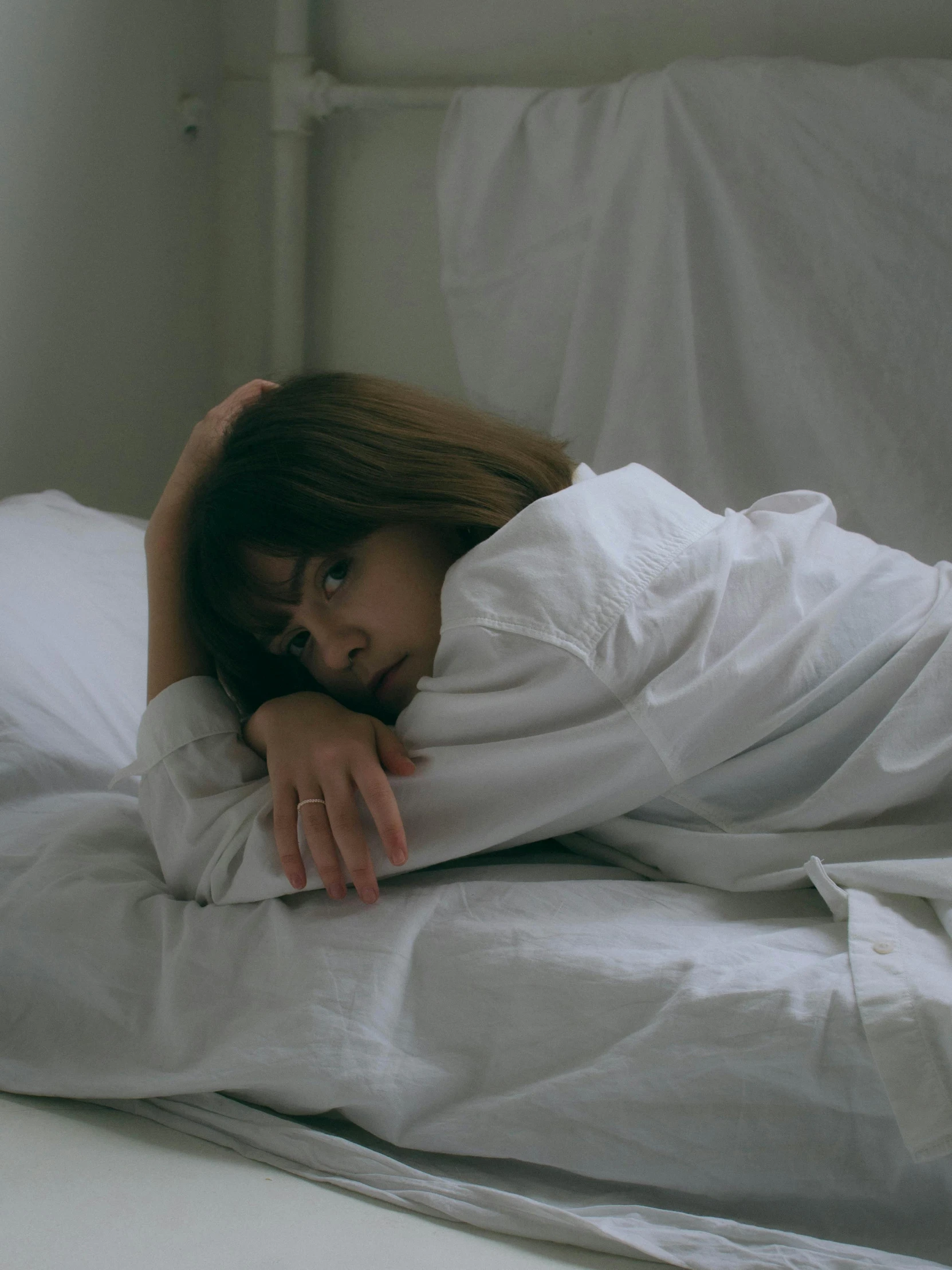 a young woman is tucked into bed with sheets