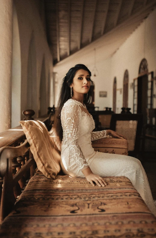 woman in white sitting on top of a dresser