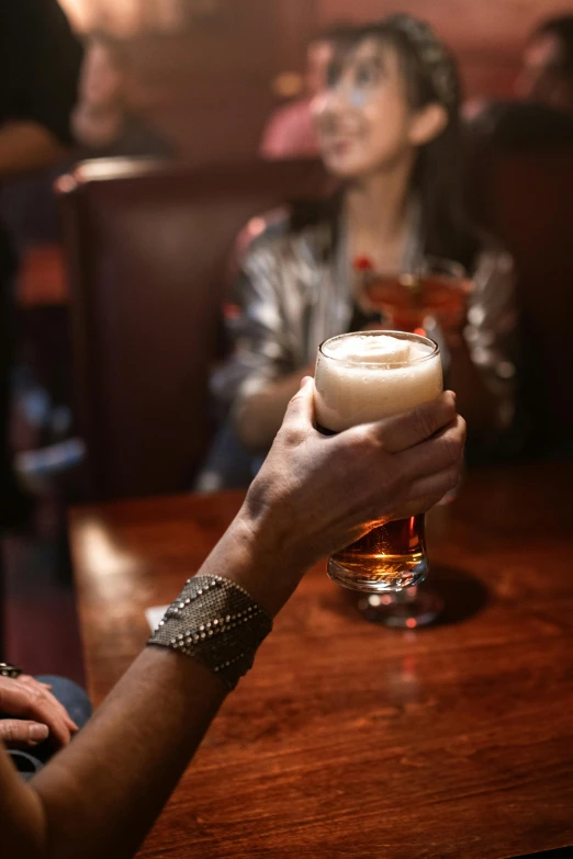 people sitting at tables drinking glasses of drinks