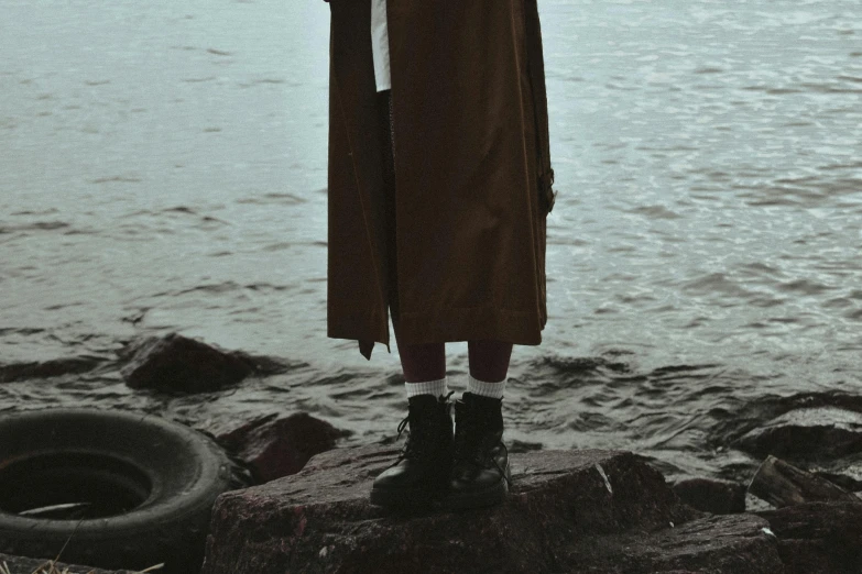 a person standing next to water with an umbrella