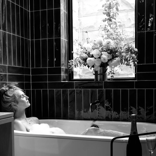 a woman that is laying down in a bath tub