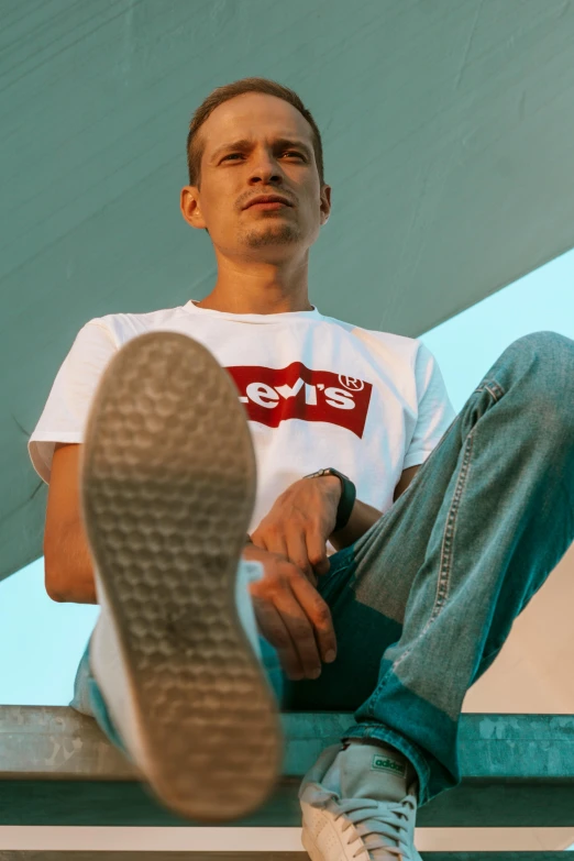 a man sitting on top of a metal bench