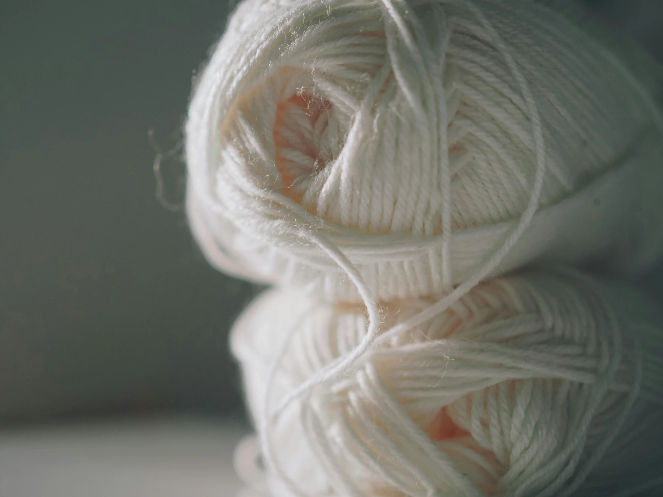 four skeins of white yarn are stacked together