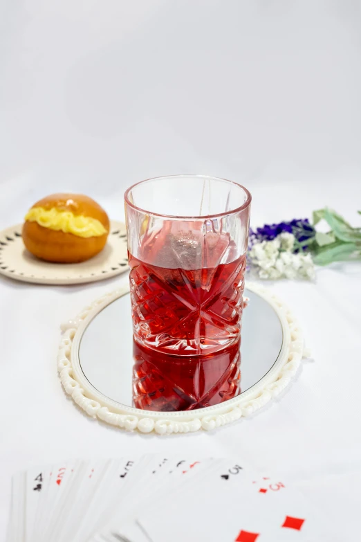 a close up of a glass of liquid near some cards and food