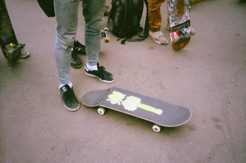 the skateboard is laying on the sidewalk next to people