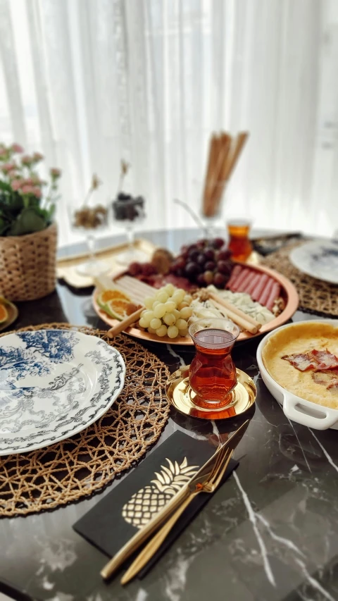 a dining room table covered in plates and cheese, bread and gs