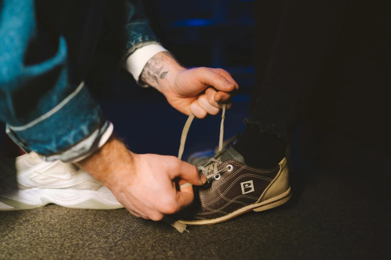 a man tying his shoes to a pair of shoes