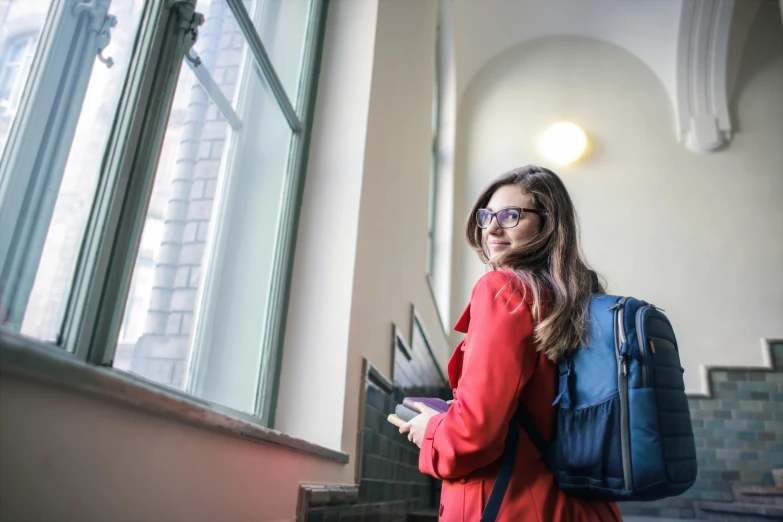 a woman in glasses is looking at her phone