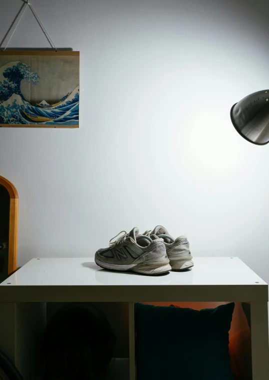 shoes and lamp sitting on a white desk in the corner