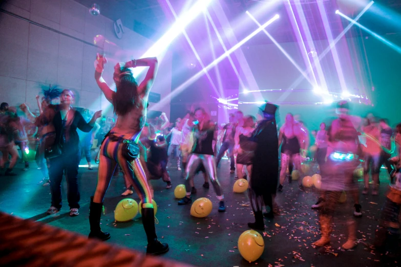 a group of people dancing in front of bright lights