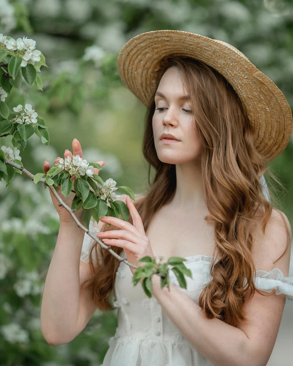 the girl in a straw hat is holding flowers