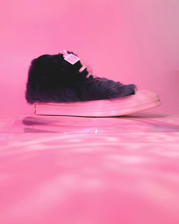 a pair of black and white shoes in a pink room