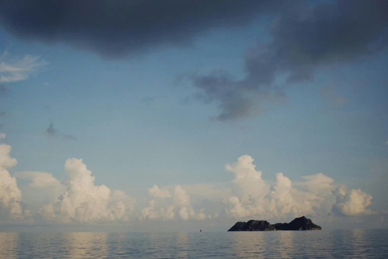 an island with rocks is floating on the water