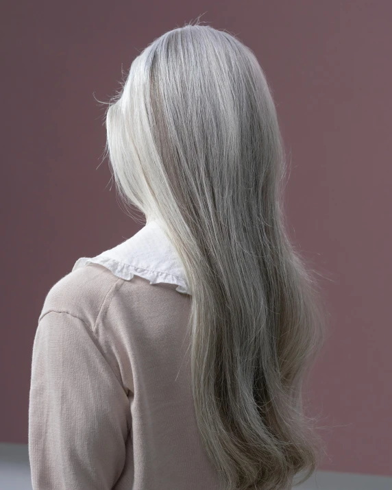 a woman with long white hair has a straight, sleek mane