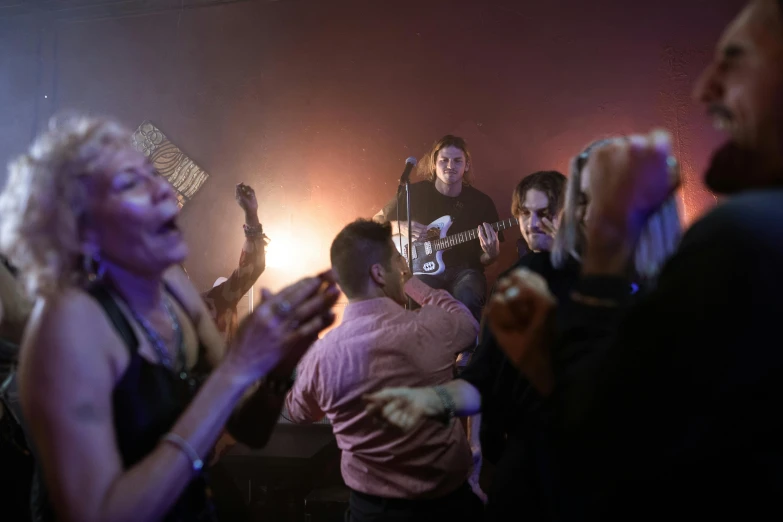 a group of people in a room with some playing instruments