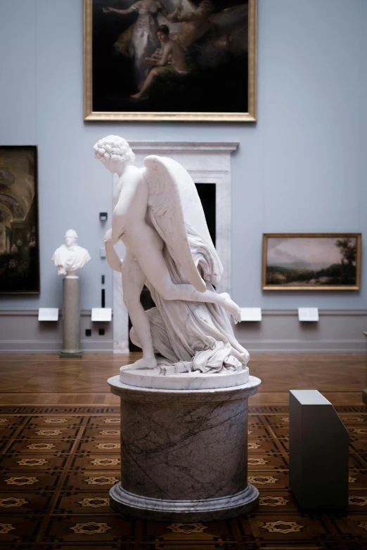 the statue stands near two paintings of men