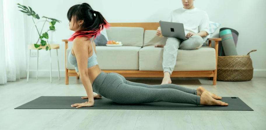 a woman doing yoga on a mat near her man
