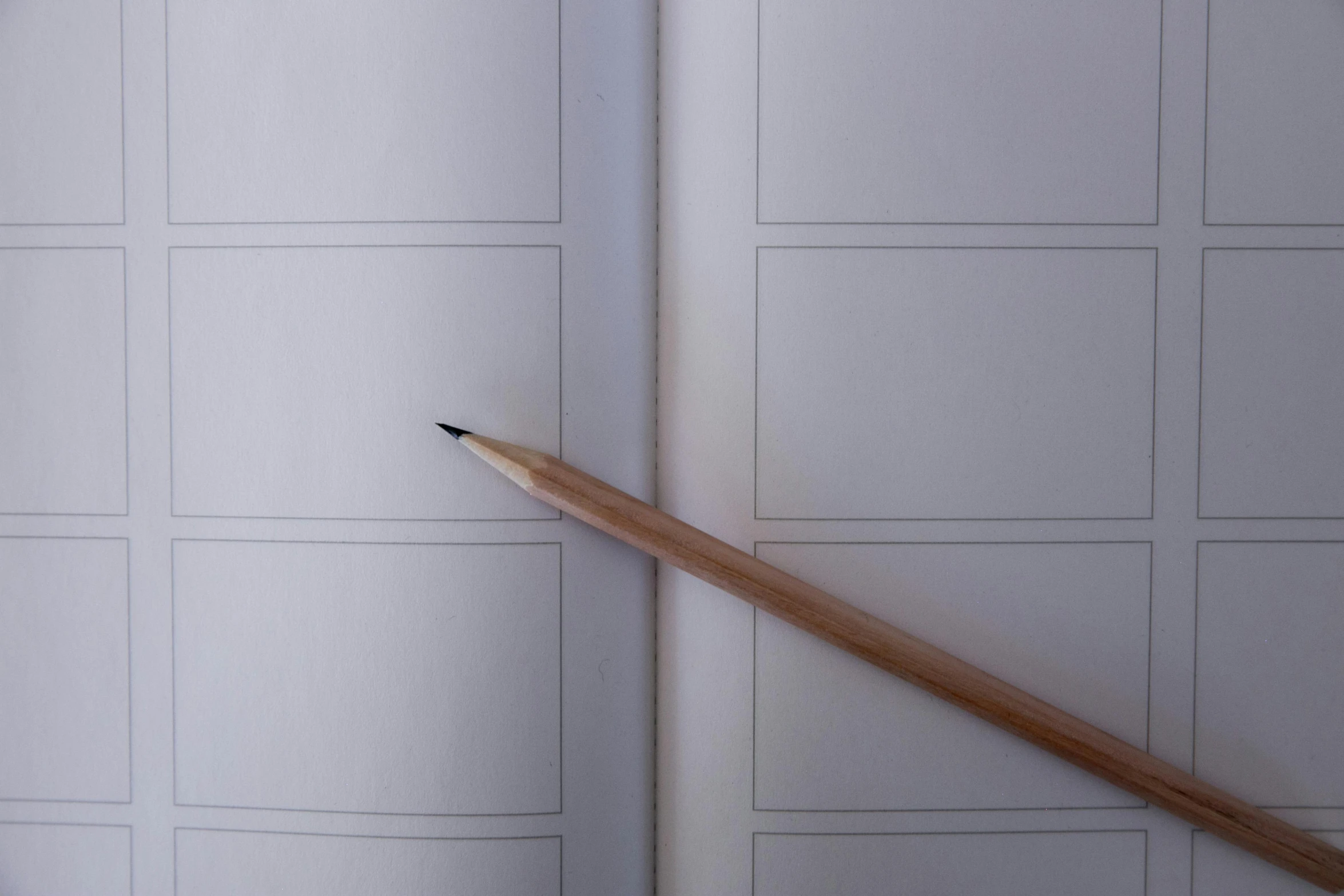 the inside of an open book and wooden pencil