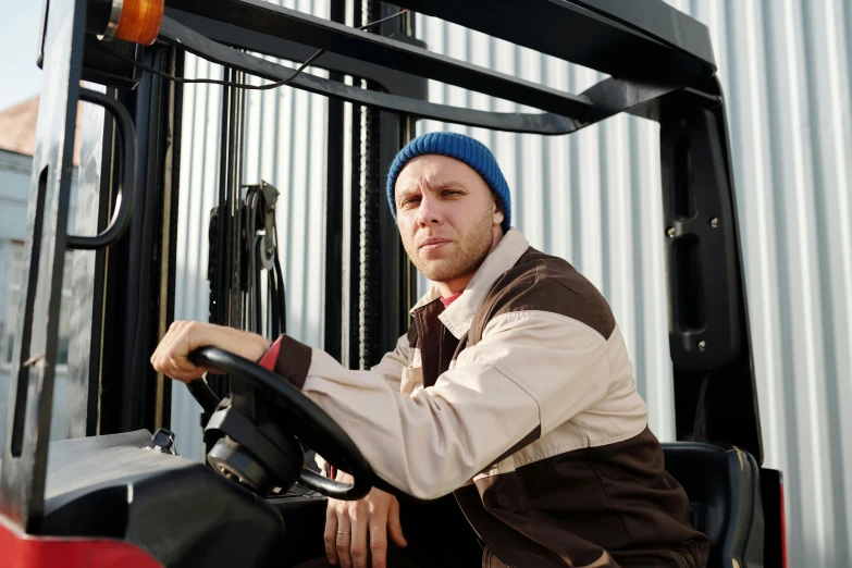 the person in a vest is on a forklift