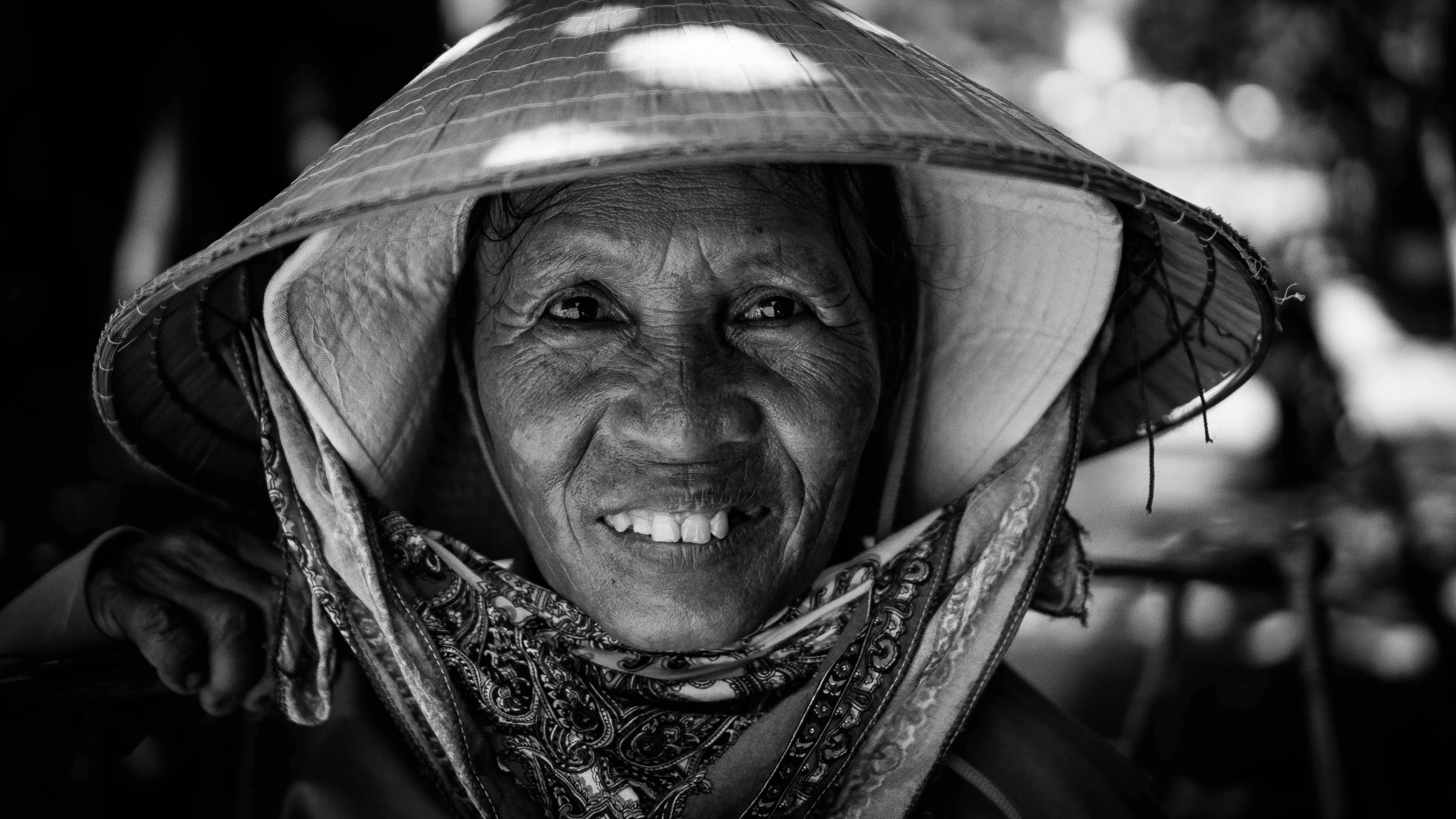 a woman in a floppy hat smiles at the camera