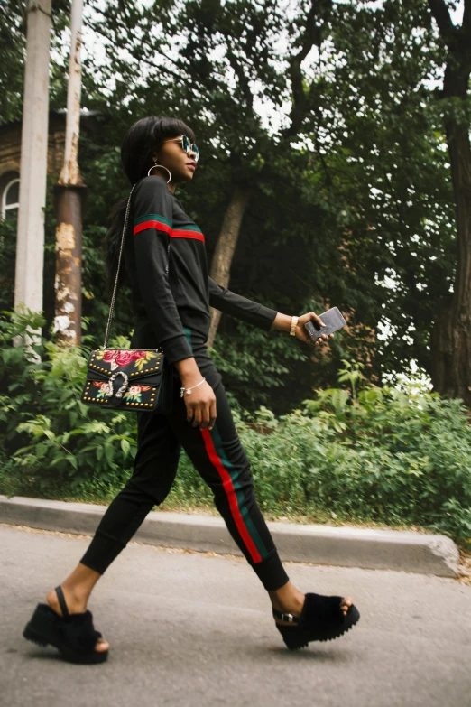 a woman is walking down a street holding her purse