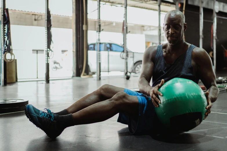 a man holding a medicine ball in a gym