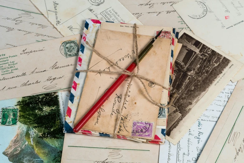 an envelope on top of old mail with red writing