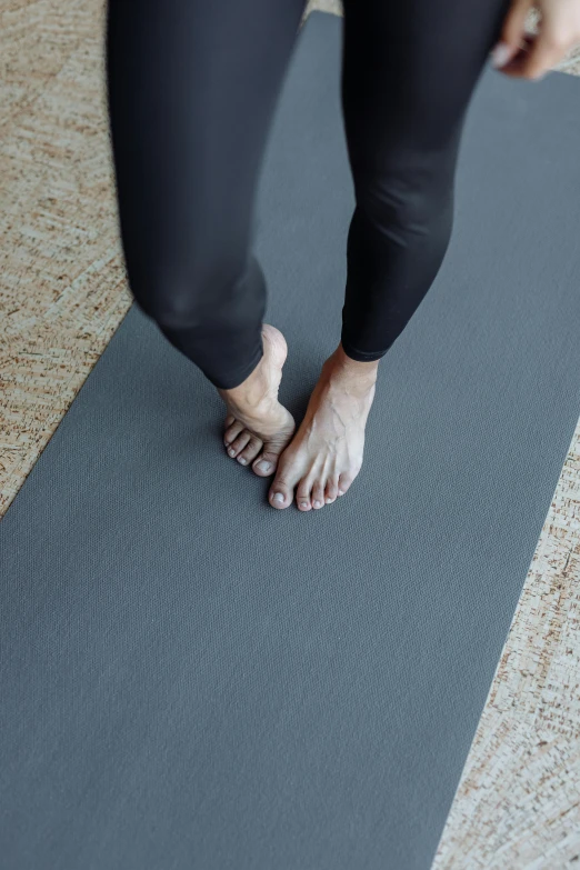 someone standing on a yoga mat in the middle of the floor