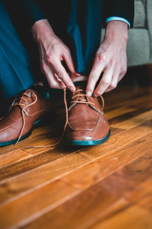 a close up of a person tying soing in a pair of shoes