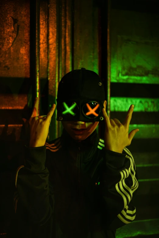 a person wearing a black hoody and neon glasses covering their eyes