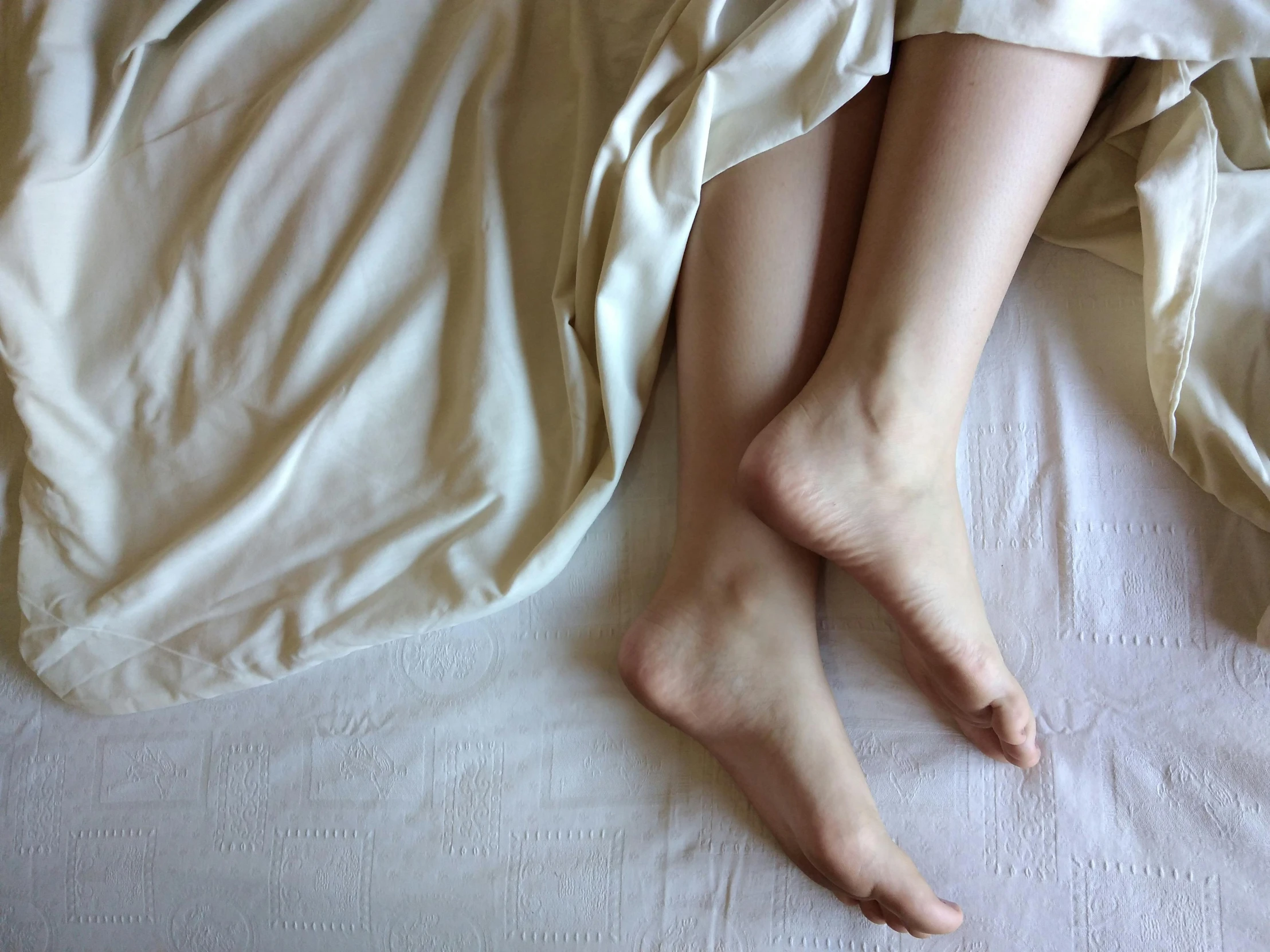 the feet of someone sleeping on a bed