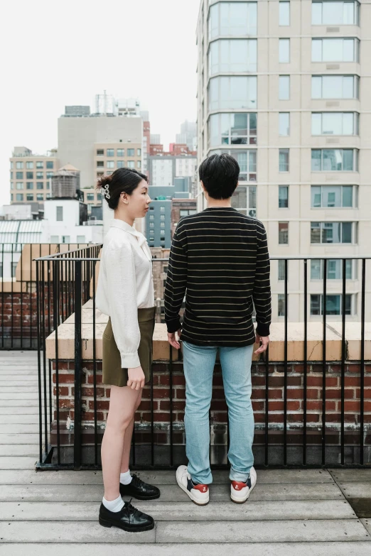 two people are standing near the railing outside