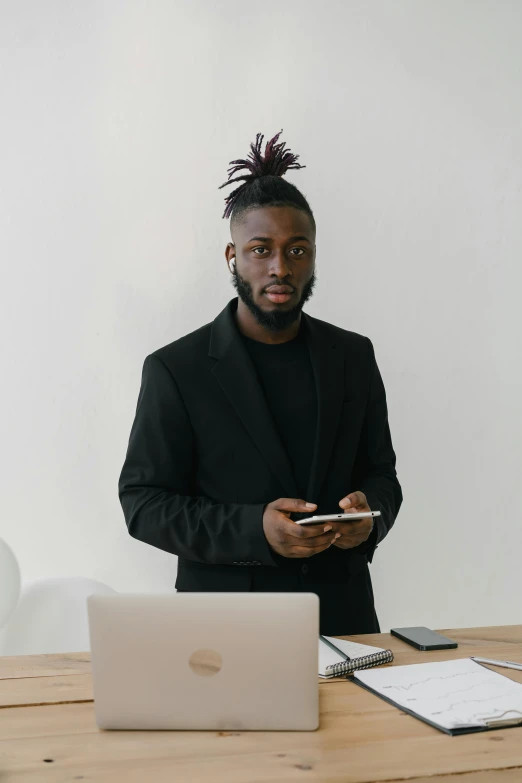 a man is standing at a table looking at his phone