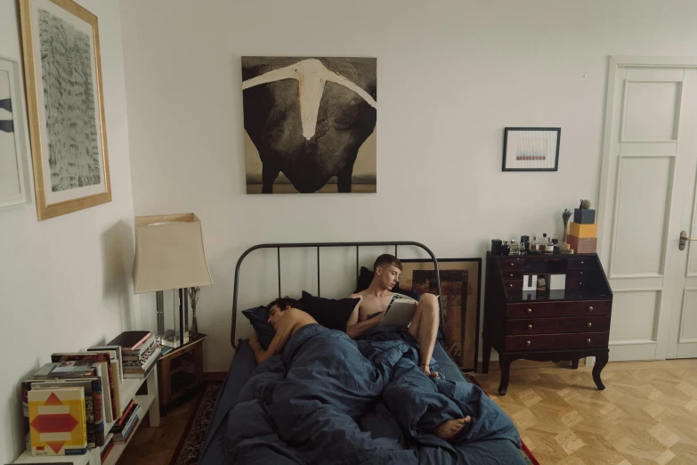 two people are laying in beds with a book