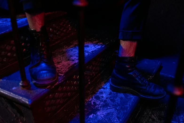 two shoes sitting on the floor as people walk in the dark