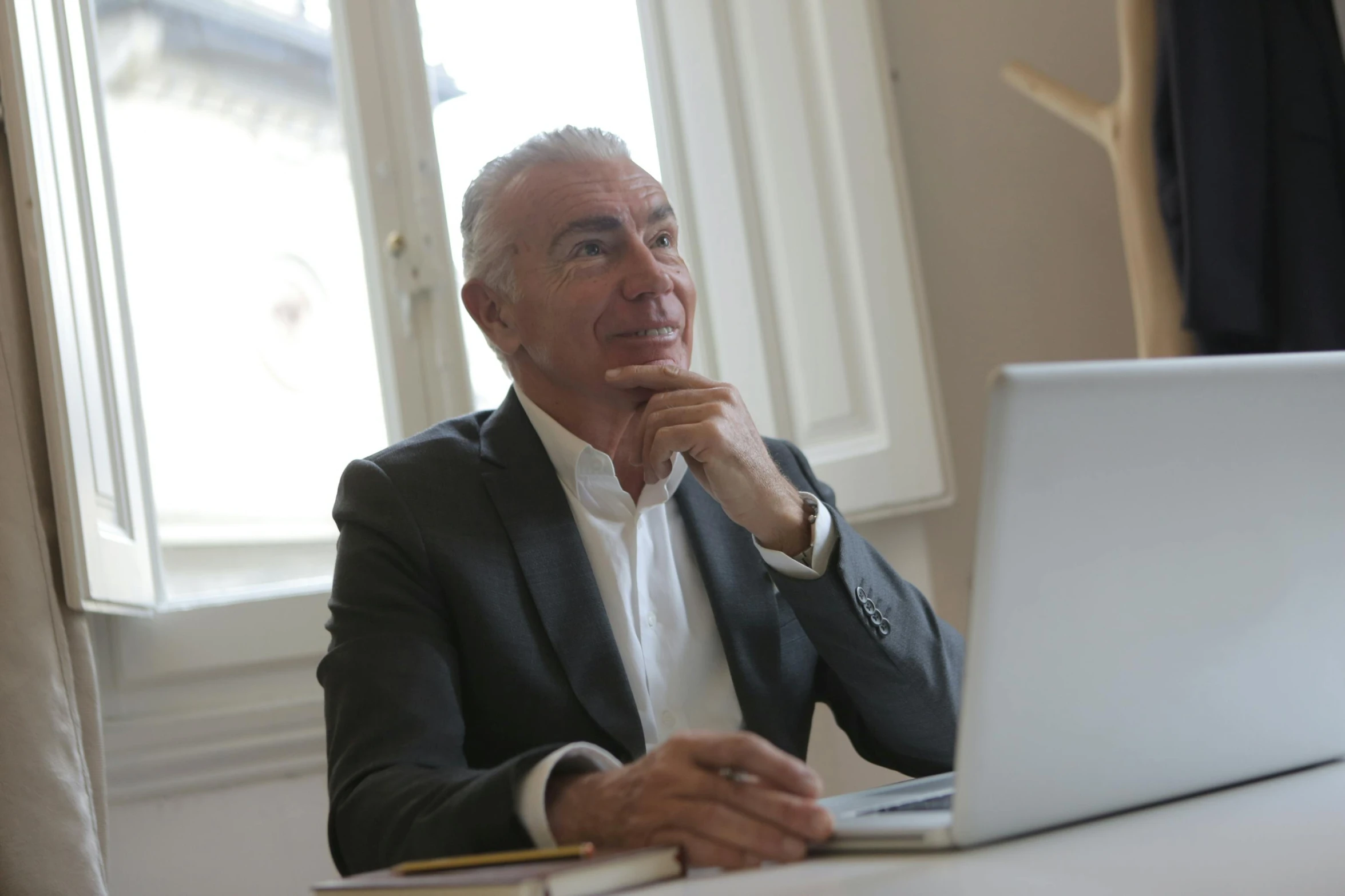 a man sitting at a table with his laptop computer