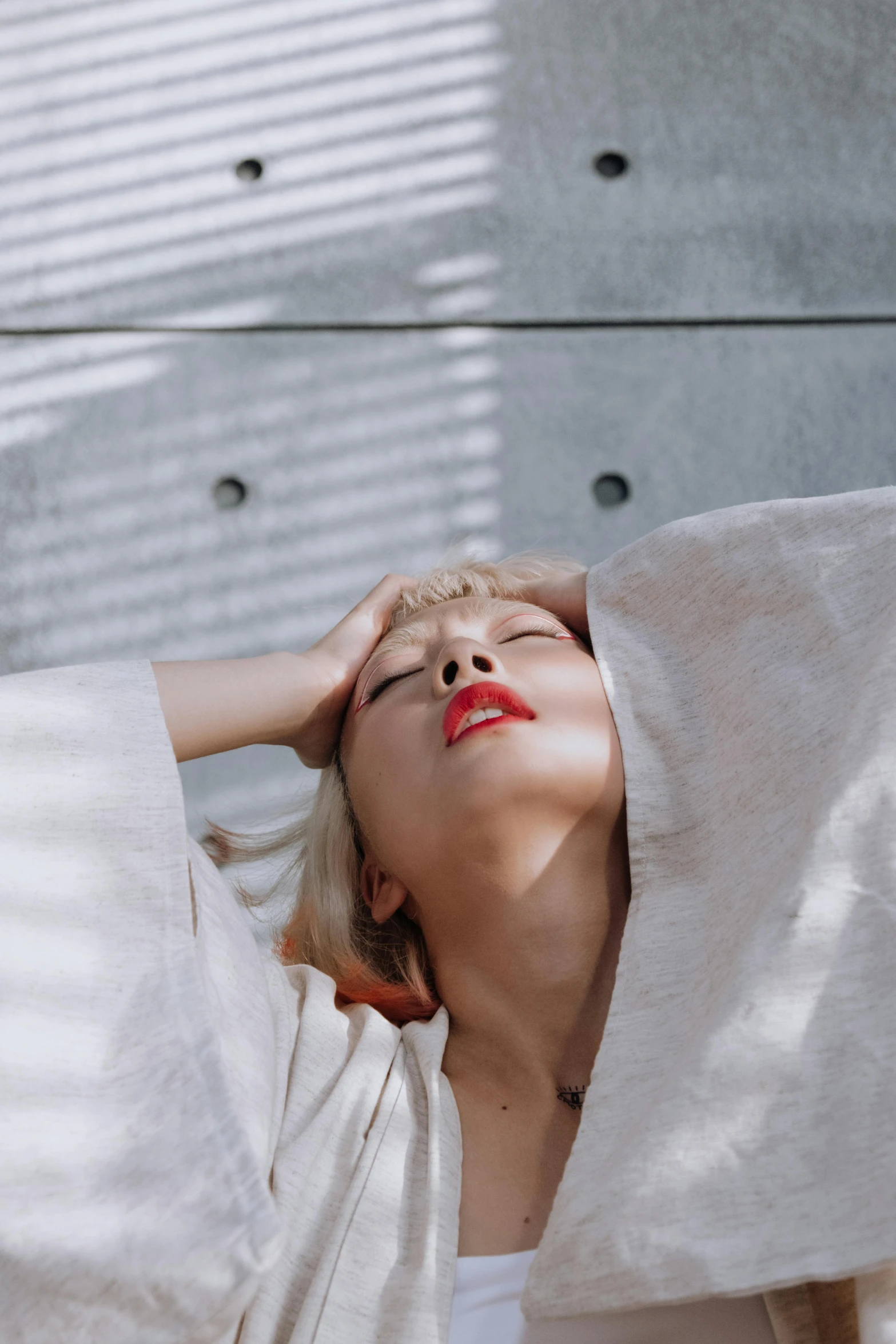 a woman with eyes closed, laying in bed