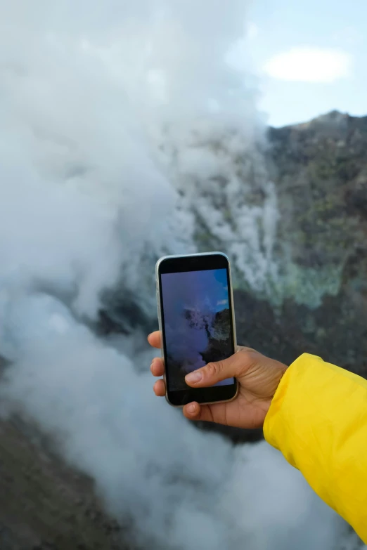 the person is holding a phone up to take a picture