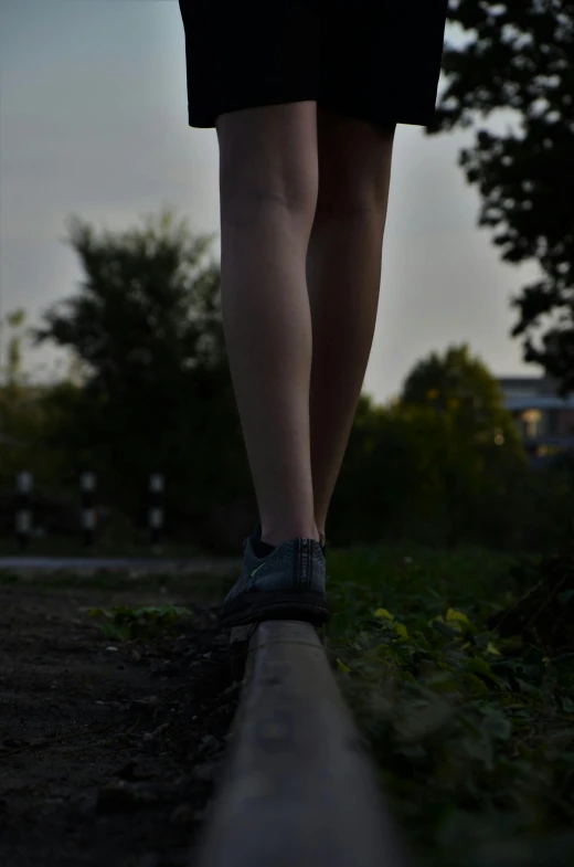 a woman wearing sneakers is walking on a street
