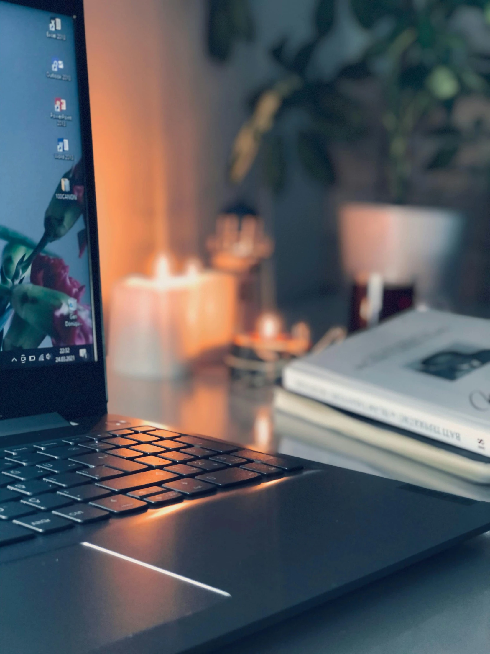 a laptop on top of a table with candles and a candlelight