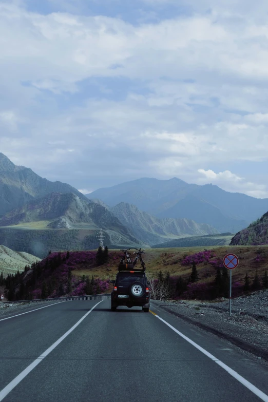 a van is driving down a road with a mountain view