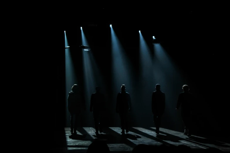 a group of people standing in the shadows