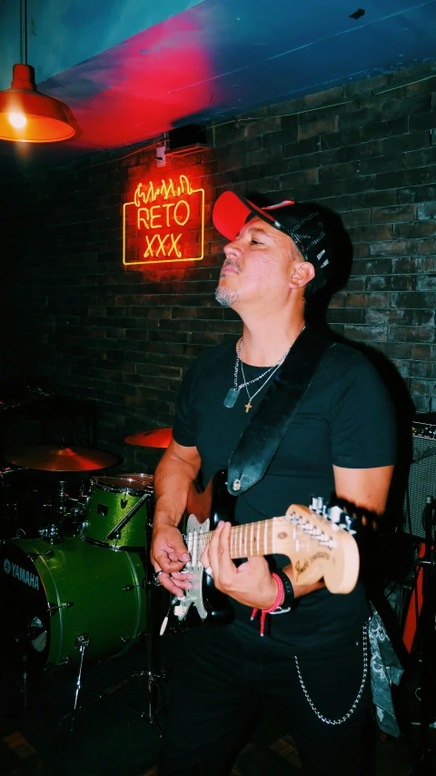 man playing a guitar while wearing red and black glasses