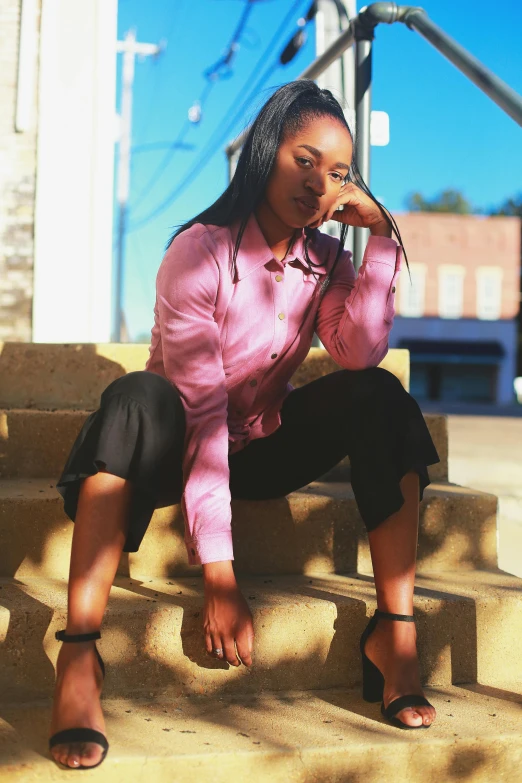 a woman sitting on some steps and looking at her phone