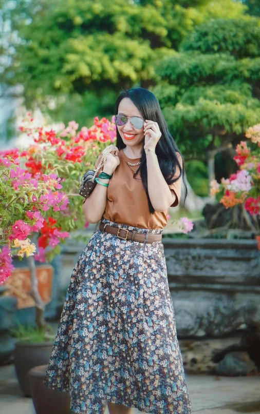 a woman in a blue dress standing in front of flowers