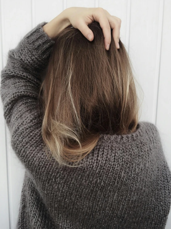 a woman covering her hair with both hands